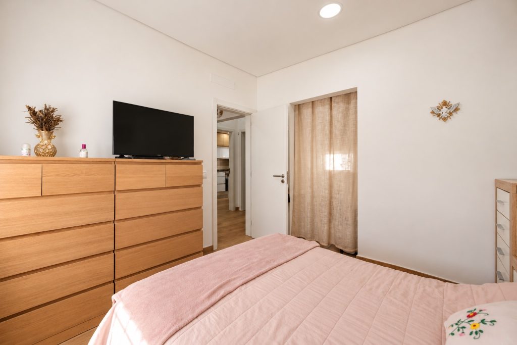 Quarto principal com cómoda em madeira e passagem para o closet da suite, moradia térrea em Santo André, Barreiro