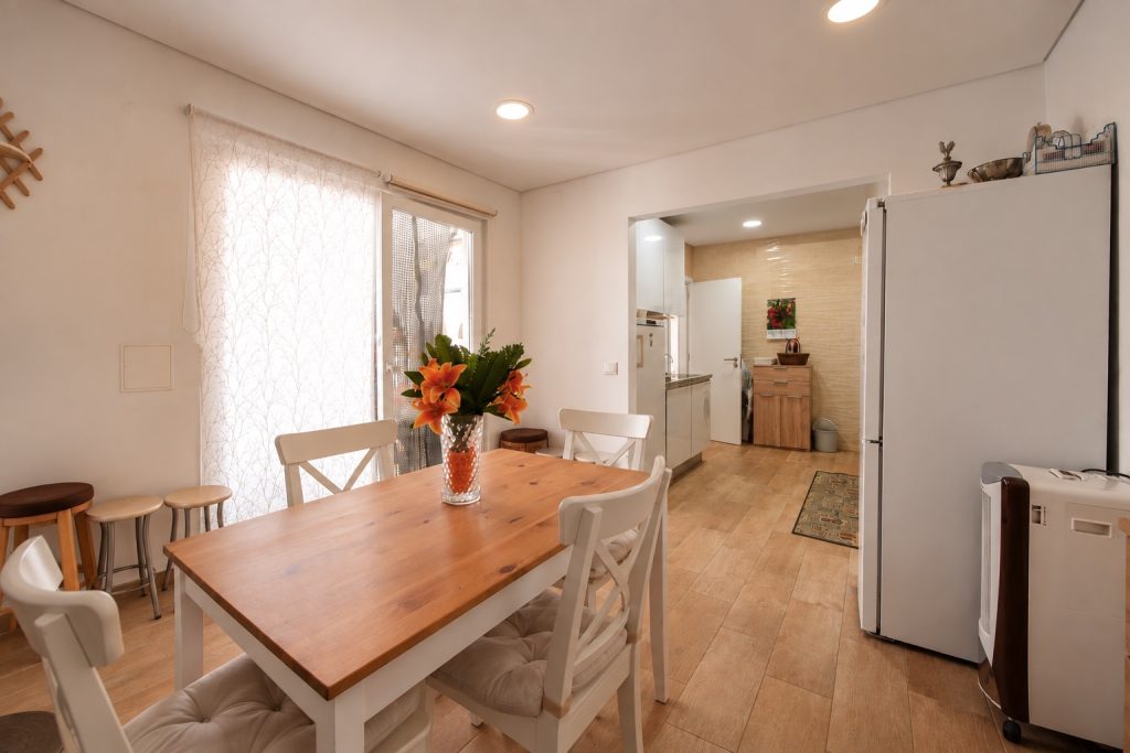 Sala de refeições com ligação à cozinha e porta de correr para o pátio, moradia T2 no Barreiro